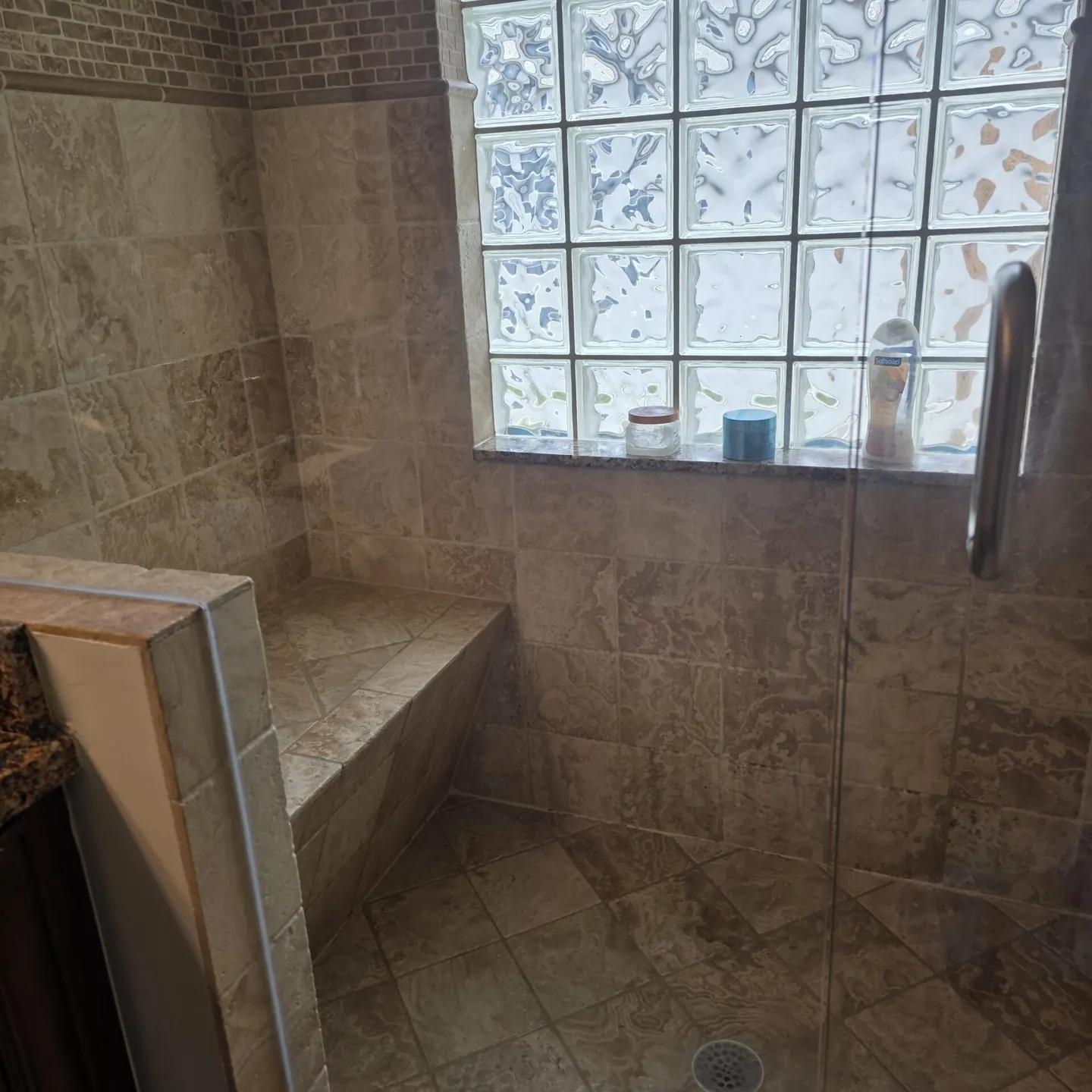 Stone-tile shower bench and floor after cleaning